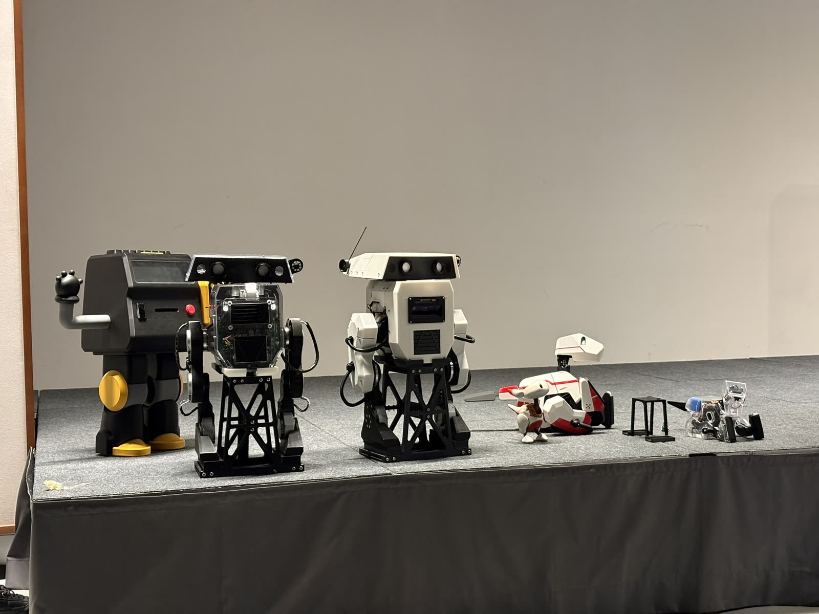Five Eyecandy robots of different sizes lined up on a stage